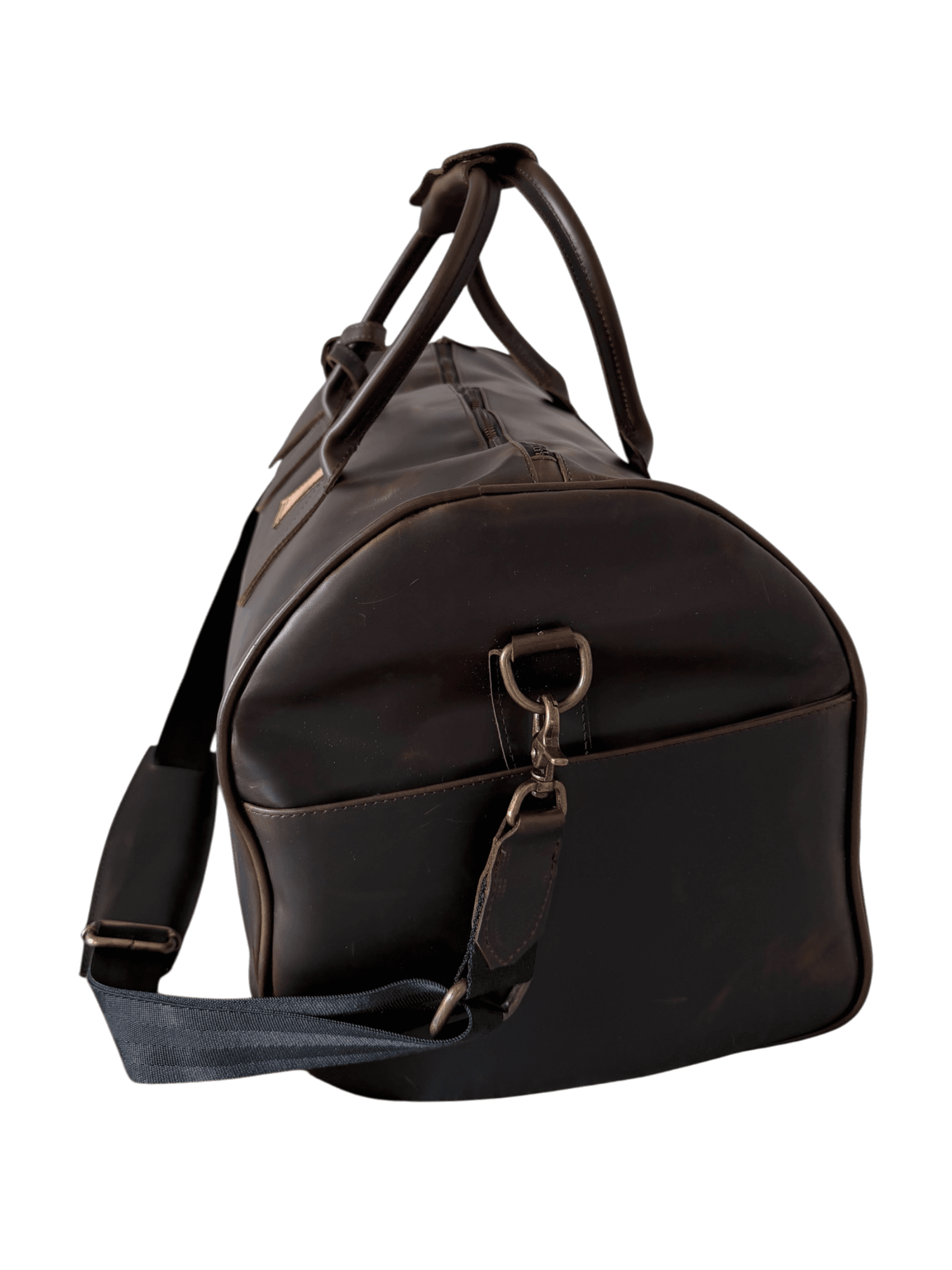 La Herencia Carryall in chocolate leather, angled studio view