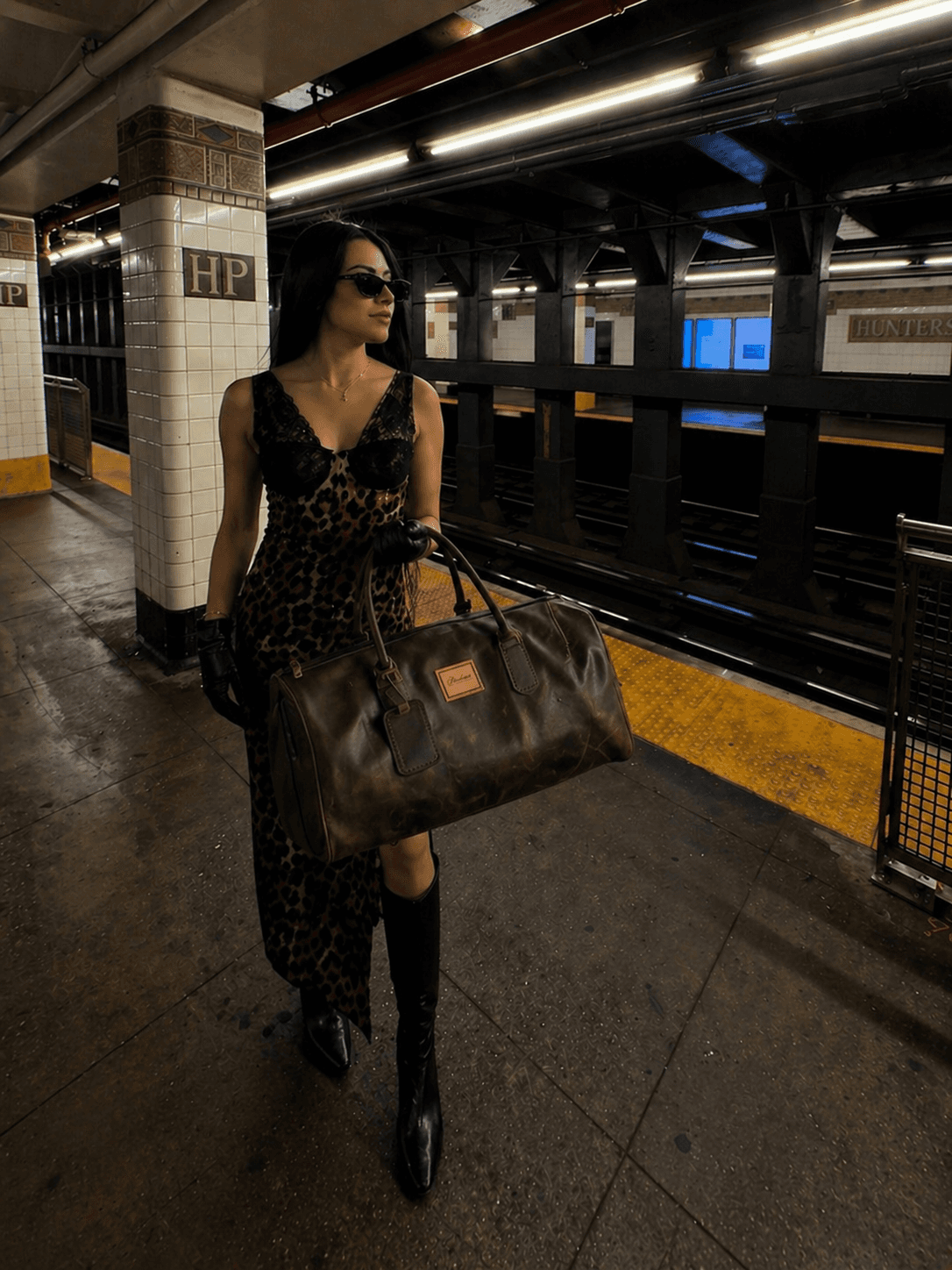 Model carrying La Herencia Carryall in chocolate leather in the city